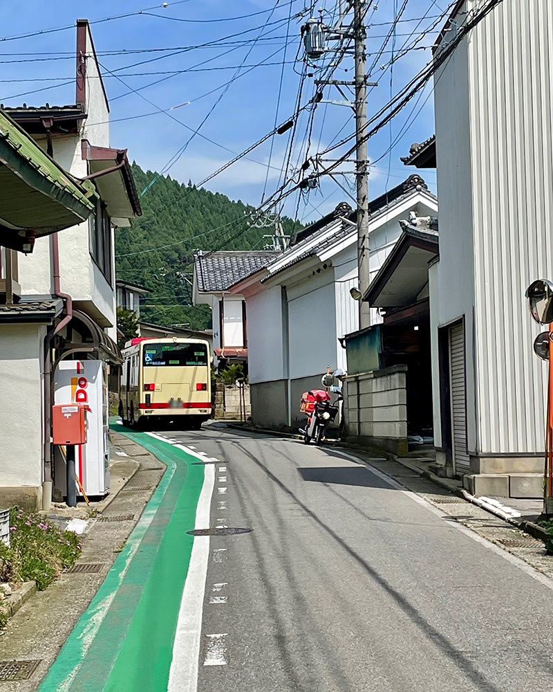 狭い道をバスが通る写真